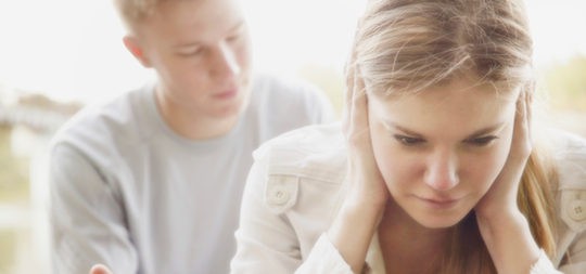 Mujer llorando mientras su novio intenta consolarla